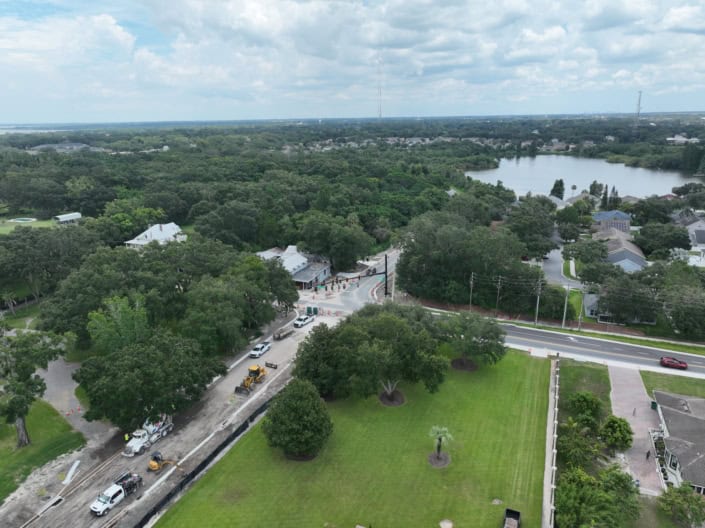 Aerial view of residential neighborhood with site development construction, green landscaping, and surrounding lakes, showcasing professional site development services.