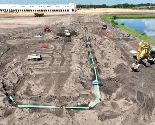 New construction site with underground plumbing and foundation preparation, showcasing site development and earthwork services.