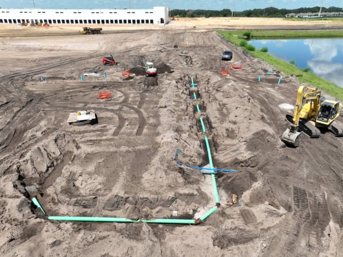 New construction site with underground plumbing and foundation preparation, showcasing site development and earthwork services.