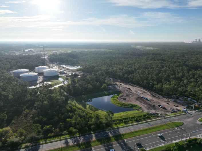 Aerial view of Site Development with construction area, water tanks, and surrounding greenery in Florida.