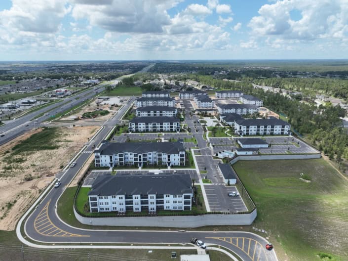 Modern multi-family apartment complex developed by SDC Site Development, showcasing efficient land use and infrastructure planning, with extensive parking and landscaped areas.