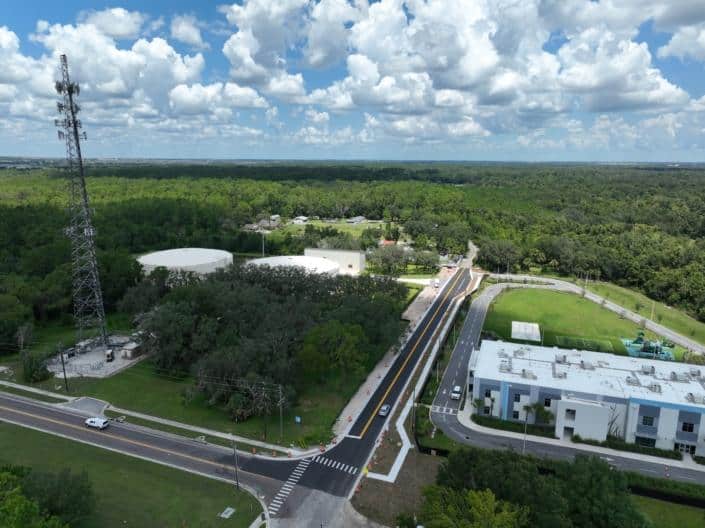 Aerial view of ongoing site development at SDC, showcasing infrastructure, roads, and surrounding greenery in a lush environment.