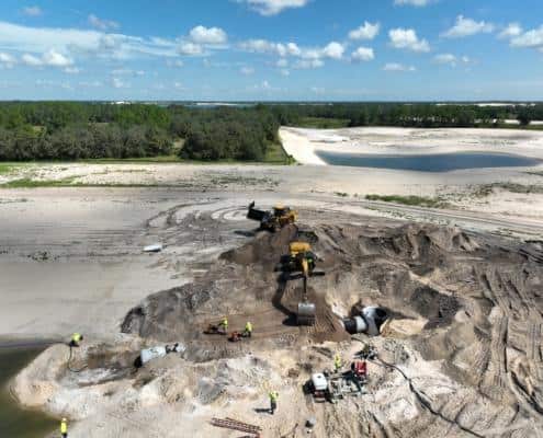 Heavy construction site with excavation equipment on a sandy landscape during site development for a new project.