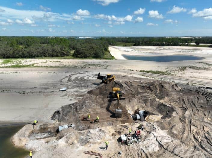 Heavy construction site with excavation equipment on a sandy landscape during site development for a new project.