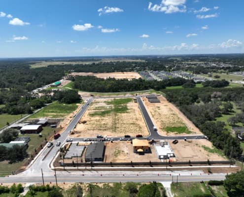 Vacant land development site for commercial or residential construction in Florida with paved roads and new infrastructure.