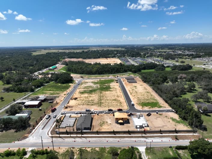 Vacant land development site for commercial or residential construction in Florida with paved roads and new infrastructure.