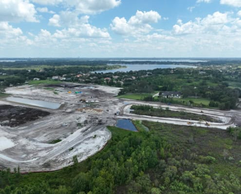 An aerial view of site development construction with heavy machinery, cleared land, and new infrastructure in progress, showcasing modern development and land preparation.
