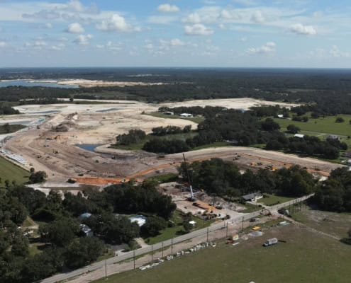 Aerial view of site development in Florida showcasing construction, earthmoving equipment, and land excavation for new infrastructure.