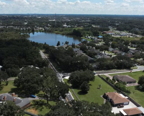 Aerial view of suburban neighborhood with trees, lakes, and residential homes, showcasing site development and community planning in Florida.