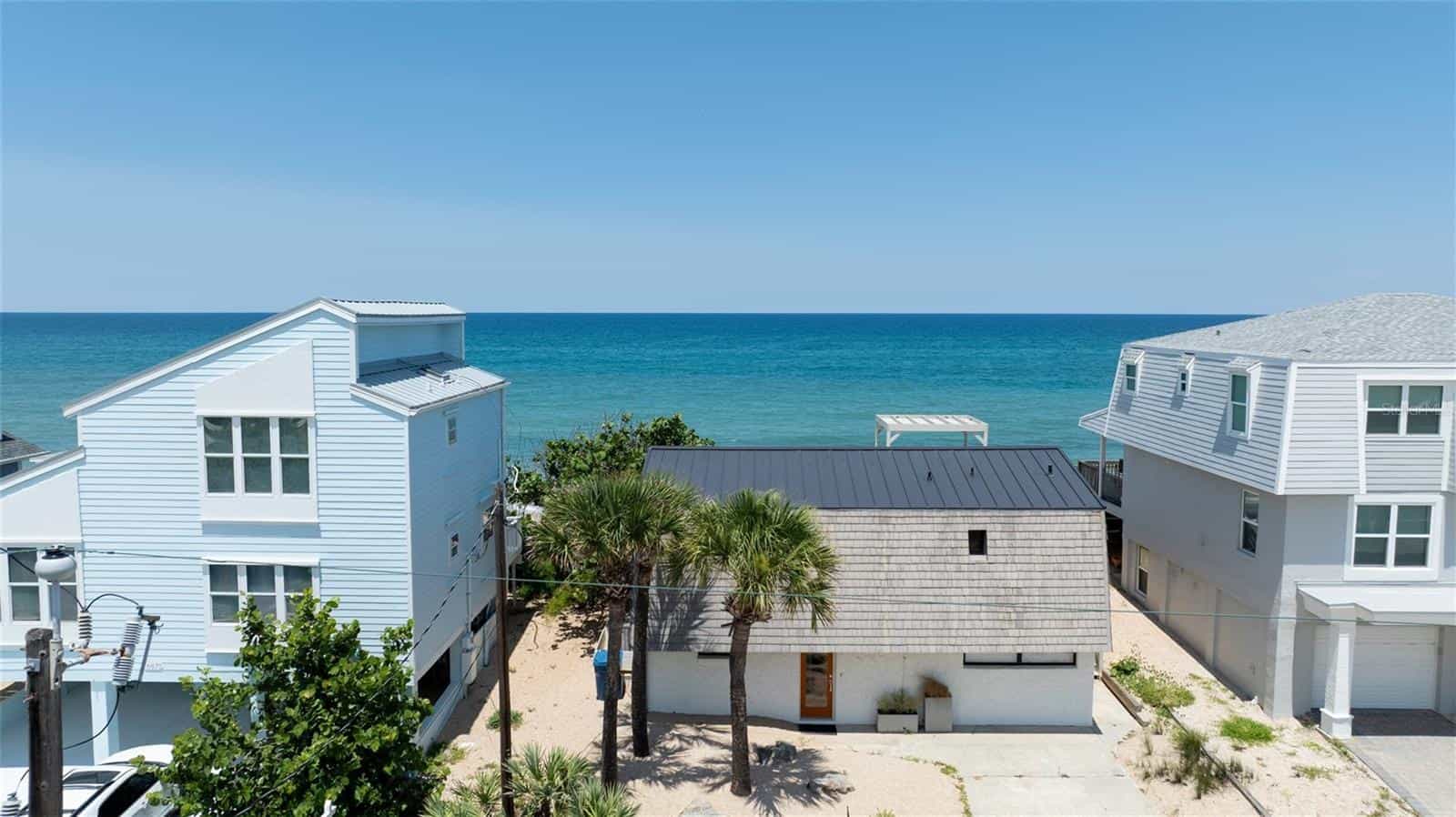 Oceanfront beach house with modern design, coastal architecture, and scenic views for beachfront property development and vacation rentals.