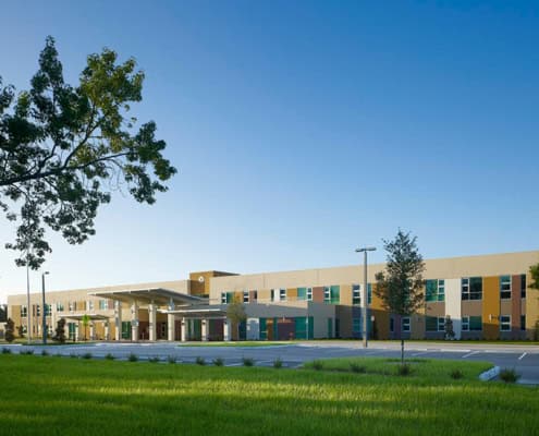 Smooth modern building exterior with colorful facade and landscaped surroundings for site development.