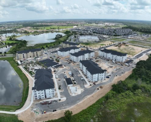 Modern residential complex under construction with multi-story apartment buildings, site development, and landscaping, showcasing professional site development services for housing projects.