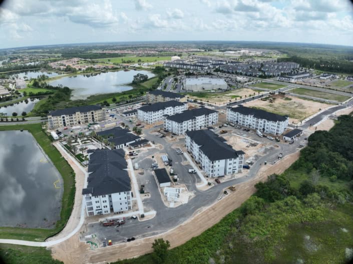 Modern residential complex under construction with multi-story apartment buildings, site development, and landscaping, showcasing professional site development services for housing projects.
