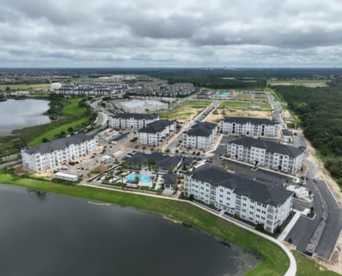 Modern residential apartment complex with water views and landscaped amenities for outdoor living and community recreation.