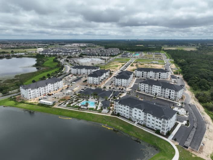 Modern residential apartment complex with water views and landscaped amenities for outdoor living and community recreation.