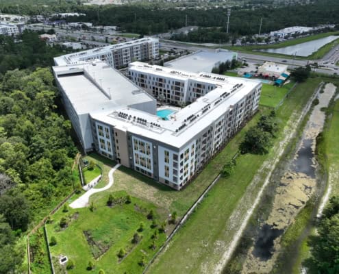 Modern apartment complex with rooftop pool and surrounding green space, developed by SDC Site Development.