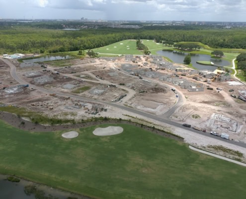 Modern commercial site development with construction progress visible, landscaped golf course, water features, and green spaces, highlighting expert site planning and infrastructure services.