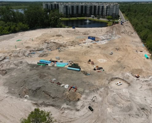 Construction site for residential development with ongoing site work, piping, and earthmoving activities at a large real estate project.