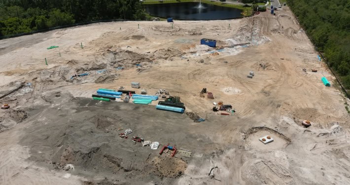 Construction site for residential development with ongoing site work, piping, and earthmoving activities at a large real estate project.