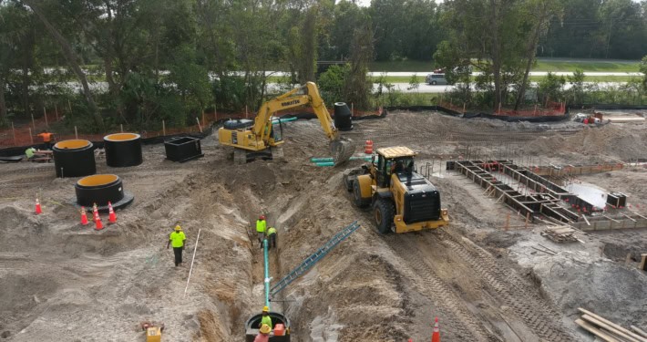 Excavation and foundation work on a commercial construction site demonstrating site development expertise and heavy machinery in action.
