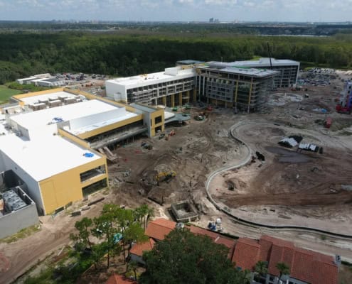 Modern commercial building under construction with active site development, machinery, and landscaping in progress at SDC Site Development.