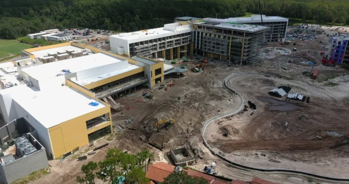 Modern commercial building under construction with active site development, machinery, and landscaping in progress at SDC Site Development.