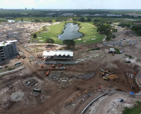 Modern golf course construction with water features and landscaping under development at a new residential community site.