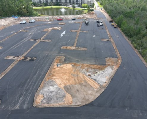 Excavation site with asphalt paving for commercial development, showcasing site preparation and grading for new construction.