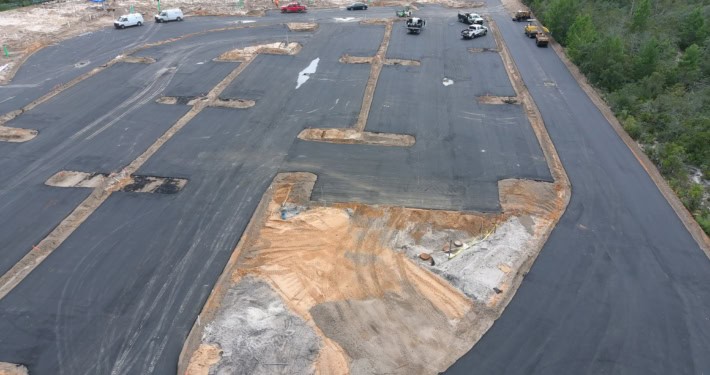 Excavation site with asphalt paving for commercial development, showcasing site preparation and grading for new construction.