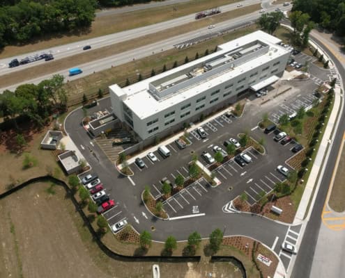 Modern commercial building with extensive parking lot, showcasing site development and urban planning expertise.