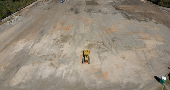 Excavation site for commercial development with heavy machinery preparing the foundation.