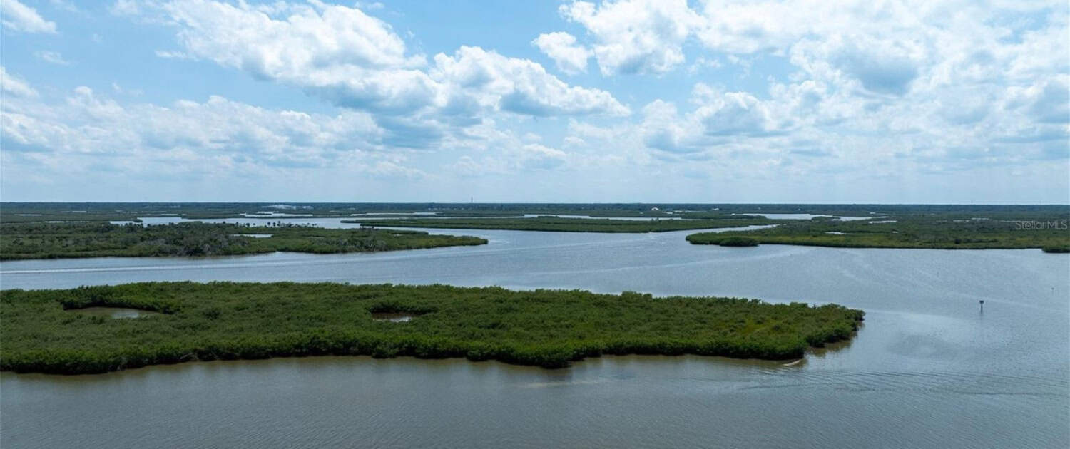 Serene river landscape with lush green islands under a partly cloudy sky, ideal for site development planning and environmental projects in Florida.