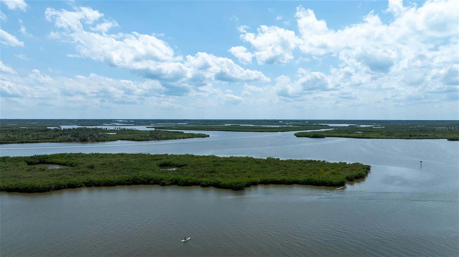 Serene river landscape with lush green islands under a partly cloudy sky, ideal for site development planning and environmental projects in Florida.